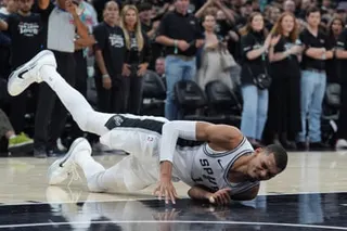 Victor Wembanyama falls to the court during Spurs playoff game in San Antonio.