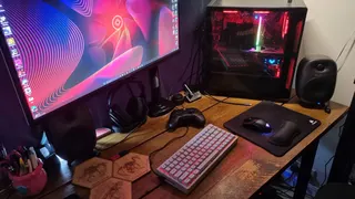 A Keychron K2 HE Concrete Edition gaming keyboard on a desk, next to a gaming PC