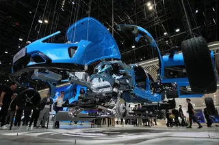 Visitors view a physical exploded model of a Xiaomi SU7 at Auto China 2026 in Beijing. Photo: AP