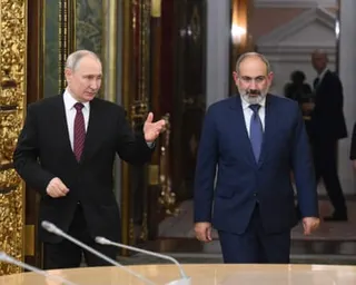Nikol Pashinyan and Vladimir Putin walk down a corridor