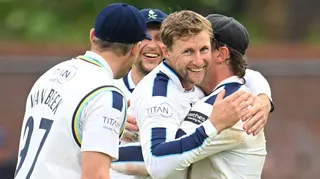 Joe Root is hugged by his team-mates after taking a wicket for Yorkshire against Somerset