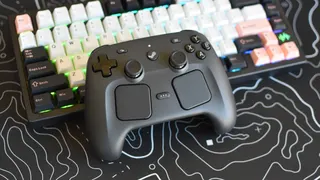 A Steam Controller laying on top of a gaming keyboard.