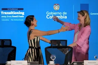 Torres and Van Veldhoven stand and make to embrace on stage