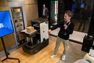 A man stands next to a robot.