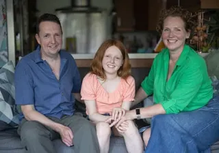 The family smile on the sofa