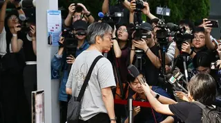 一名宏福苑居民到位於中環展城館聽證會現場，接受在場多間傳媒訪問。