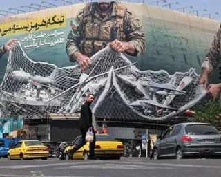 Vehicles drive past a giant billboard reading ‘the strait of Hormuz remains closed' at the Revolution Square in Tehran last week.