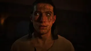 A man with a dirty face and glossy white eyes is stood with a slightly confused expression in The Blood of Dawnwalker.