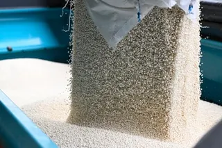 Ammonium nitrate fertiliser is poured into a spreader.