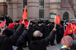 居民集会时，保安人员在一旁注视着。