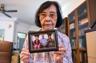 File picture of the sister of National Journalism Laureate Adibah Amin, Khalilah Fadzilah Amin, showing a photo of the siblings while being interviewed about her sister’s health. — Bernama pic