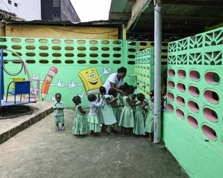 A teacher surrounded by a group of children at a nursery in Abidjan, Ivory Coast