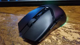 A Razer Cobra HyperSpeed gaming mouse on a wooden desk