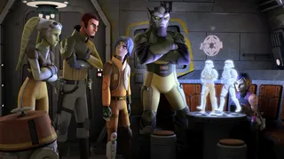 A group of aliens and humans gather around a hologram image of two stormtroopers in Star Wars Rebels