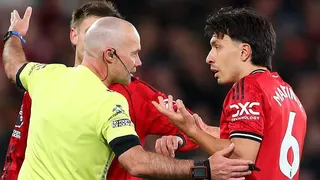 Referee Paul Tierney speaks with Lisandro Martinez of Manchester United after showing him a red card for pulling the hair of Dominic Calvert-Lewin of Leeds United