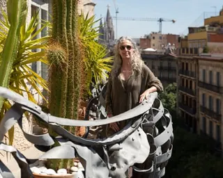 Ana Viladomiu stands on the sculpted balcony of her apartment in Gaudí's apartment building, Casa Milà