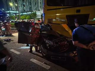 Firefighters and emergency personnel at the scene after a Proton Persona crashed into the rear of a parked school bus along the MRR2 highway near Taman Layang-Layang in Kuala Lumpur early May 4, 2026, killing a 26-year-old woman. — Bomba pic