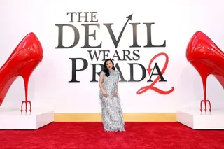 Jin Chao的扮演者沈雨田站在《穿Prada的惡魔2》版畫前。