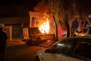 A police vehicle burns as community members clash with authorities outside Alice Springs Hospital in Australia on Thursday. Photo: EPA