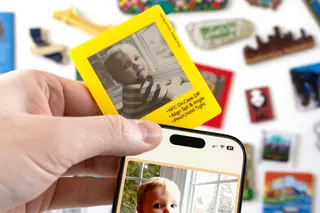 A person holds a VidaBay Snap magnetic photo frame against an iPhone where their NFC antennas align.