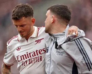 Ben White is helped off the pitch by an Arsenal physio