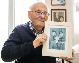 Albrecht Weinberg holds up a photograph of himself with his brother Dieter and his sister Friedel