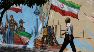 Un hombre iraní camina junto a un mural en una calle de Teherán, Irán, el 11 de mayo de 2026.