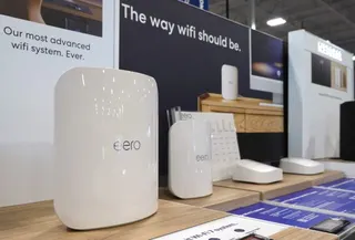 Eero Wi-Fi routers on display inside a store in front of an advertisement that says, "Our most advanced Wi-Fi system, ever."