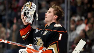 Lukas Dostal adjusting his goalie mask during a hockey game at Honda Center