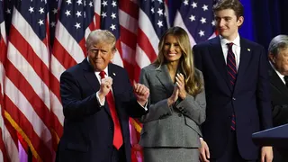 Donald Trump dancing on stage with Melania Trump and Barron Trump at an event