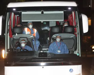 A coach carrying cruise ship passengers arrives at Arrowe Park hospital on the Wirral, with the driver and passengers wearing personal protective equipment