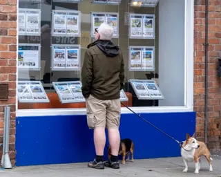 Man looking into the window of an estate agent