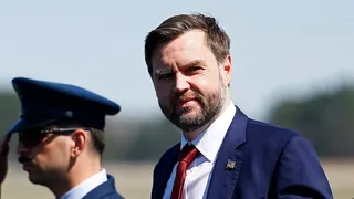Vice President JD Vance standing next to a saluting soldier