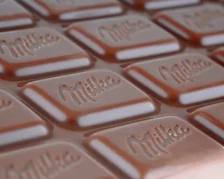 A closeup picture of a chocolate bar embossed with the word 'Milka'