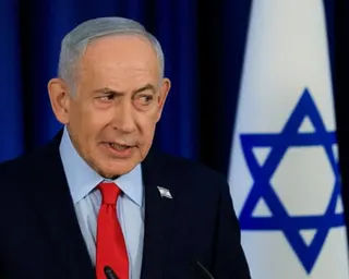 Benjamin Netanyahu speaks at a news conference in front of Israel's flag