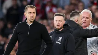 Tonda Eckert has a stern grimace on his face as Kim Hellberg looks on while the fourth official speaks to Middlesbrough coach Adi Viveash behind Hellberg