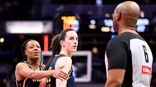 Caitlin Clark of the Indiana Fever reacting toward a referee during a basketball game.