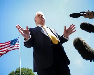 a man in a suit surrounded by microphones