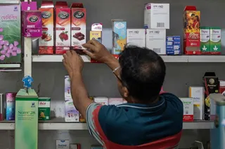 A pharmacy worker arranges packets of condoms in Dhaka on April 27. Photo: AFP