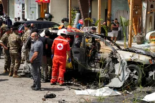 Rescuers work at the site of an Israeli strike on a car in Jiyeh