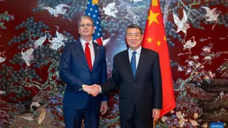 中国国务院副总理何立峰（右）与美国财政部长贝森特，周三在韩国举行经贸磋商前握手。（图取自新华社）