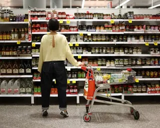 A customer in Coles looking at jars on shelves