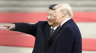 2017年11月，中國國家主席習近平（左）在北京人民大會堂外舉行的歡迎儀式上，站在美國總統特朗普旁邊做手勢。