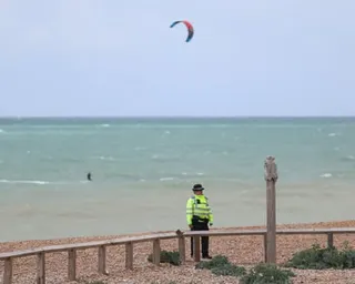 A police officer guards Brighton beach after the bodies of three young women were found