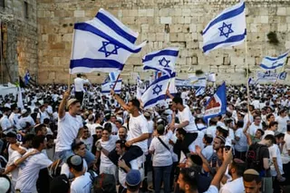 People at the Western Wall Plaza holding Israeli flags