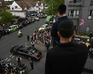 People look down from a rooftop in Golders Green, London, during King Charles’s visit on Thursday.