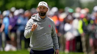 Jon Rahm waving after his putt on the sixth hole at Aronimink Golf Club