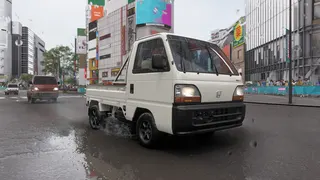 A kei truck driving through Shibuya.