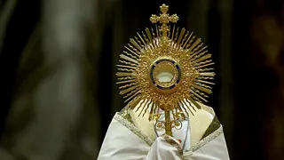 A priest holds the Monstrance during the Eucharistic adoration