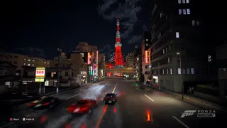 Tokyo tower at night in Forza Horizon 6 with three supercars blurred on the road before it